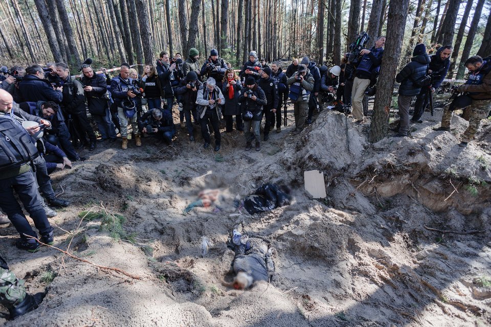 Журналісти фотографують масове поховання в Мотижині